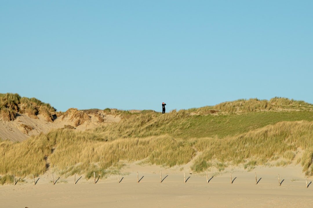 Photographer capturing golden hour light on a Danish coastline with dunes